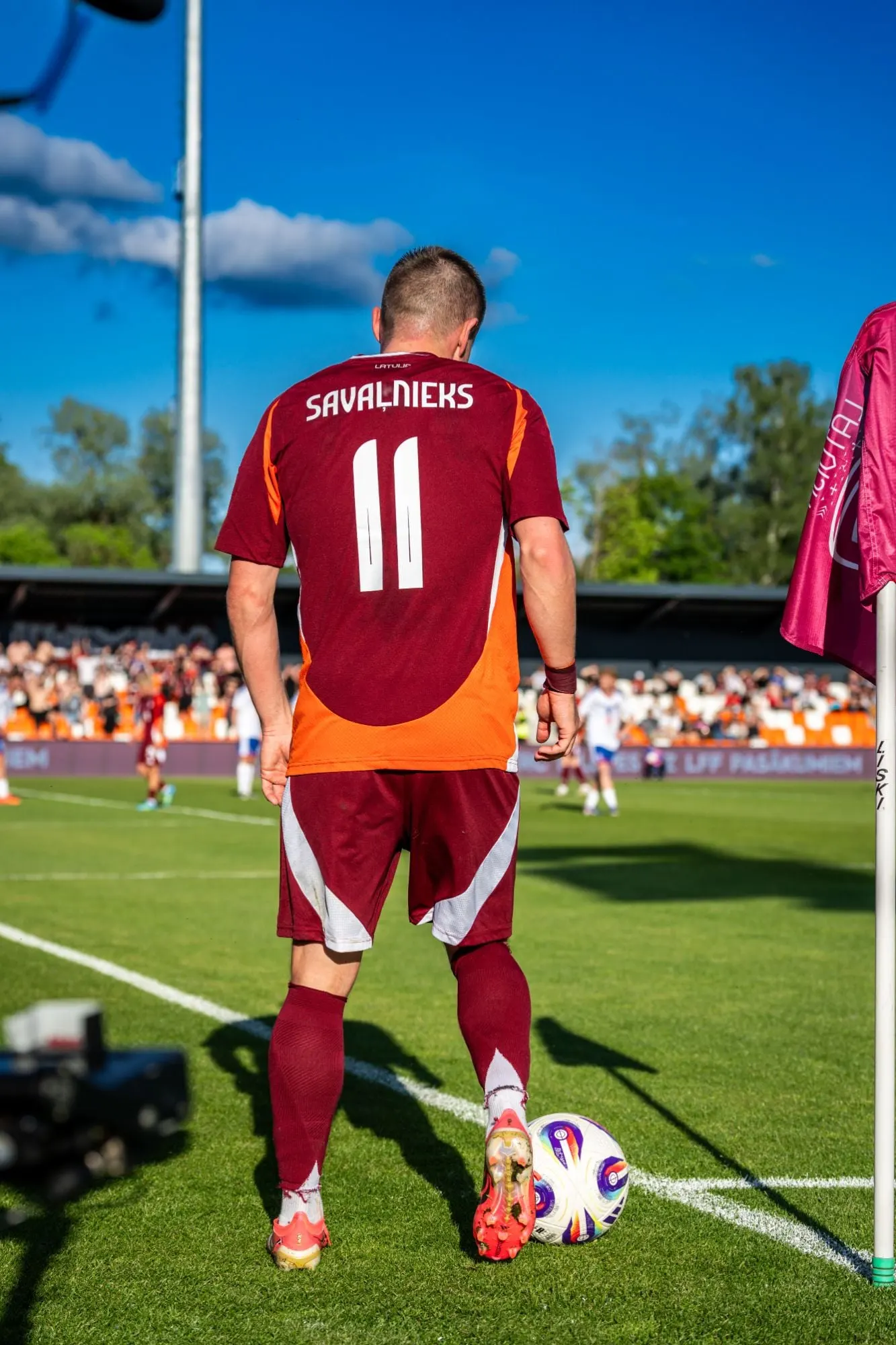Futbolists ar numuru 11 gatavojas izpildīt stūra sitienu